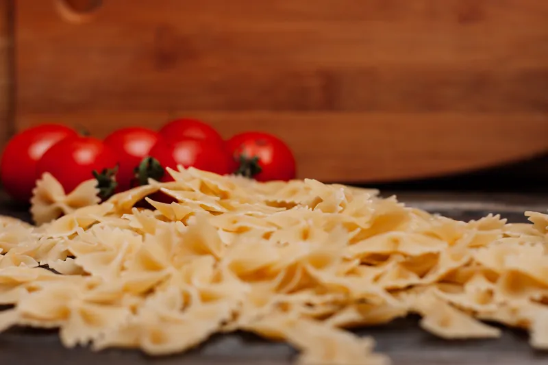 Итальянская паста, помидоры черри, разделочная доска, приготовление еды