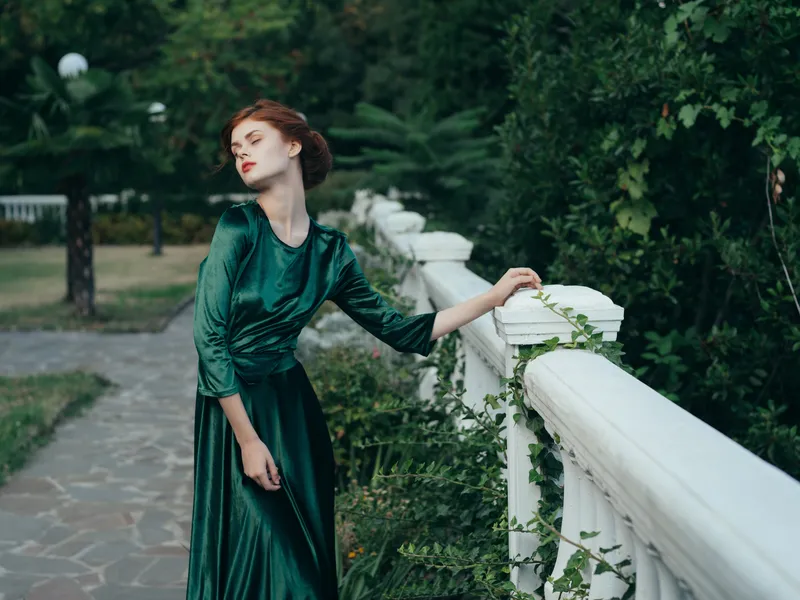 Женщина в зеленом платье в парке, роскошная романтичная прогулка