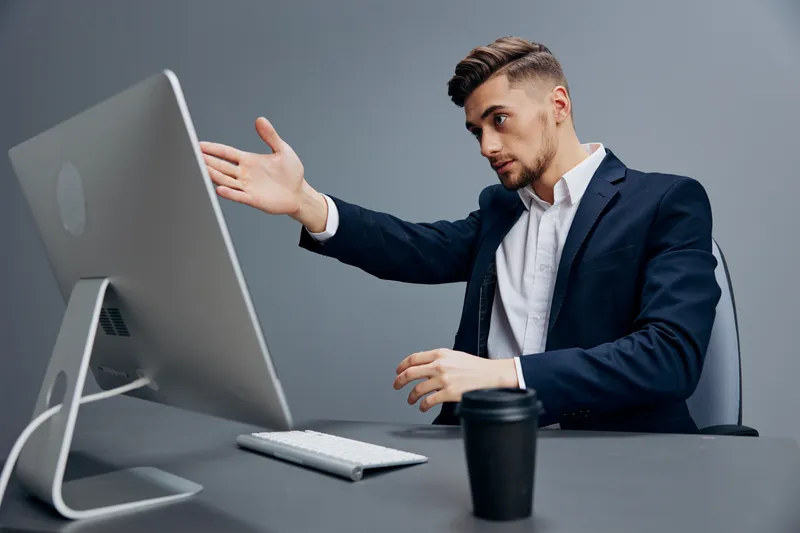 Уставшие бизнесмены с бокалом кофе работают за компьютером