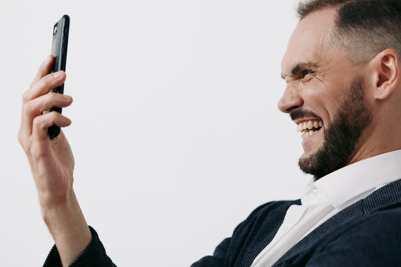 A confident business man is captured in a candid self portrait against a clean isolated color background, conveying professional mood and genuine emotion.