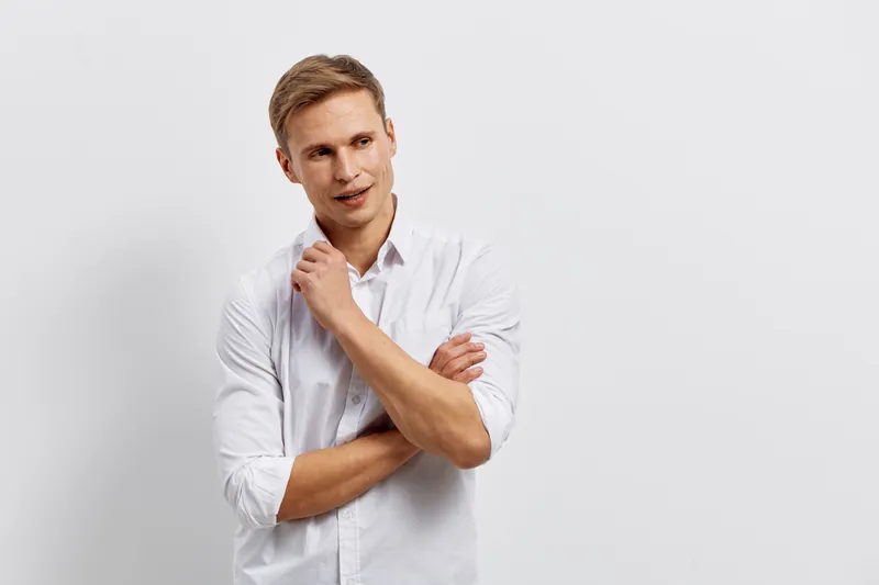 thoughtful man with white shirt look side pose isolated on plain white background casual outfit digital detox concept