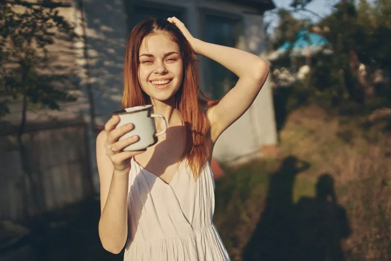 Женщина в белом платье гуляет на природе летом