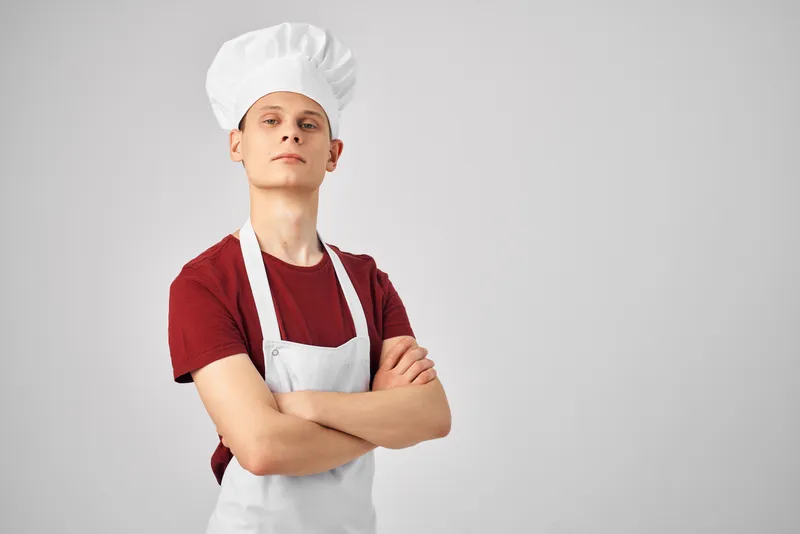 Повар-мужчина в колпаке, кухонный профессионал, светлый фон
