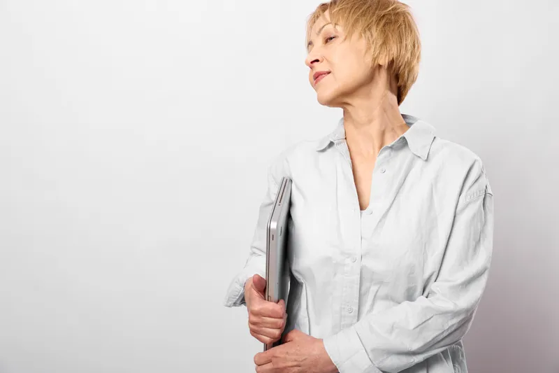 Woman portrait, smartphone in hand, white shirt, indoor studio, side view, expression calm, plain background, soft light, copyspace