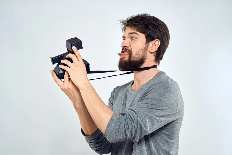Фотограф-мужчина с профессиональной камерой, работа, студия, технологии, современное искусство, светлый фон
