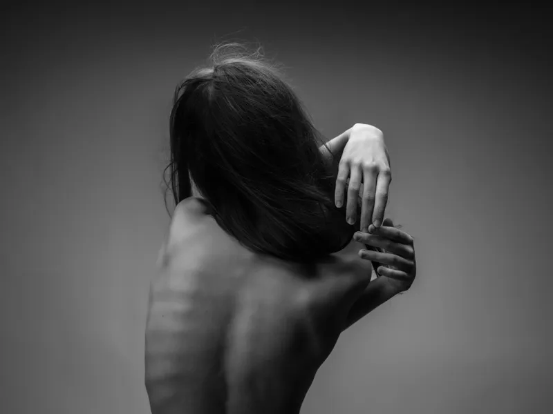 Спина обнаженного женского тела в черно-белой фотографии