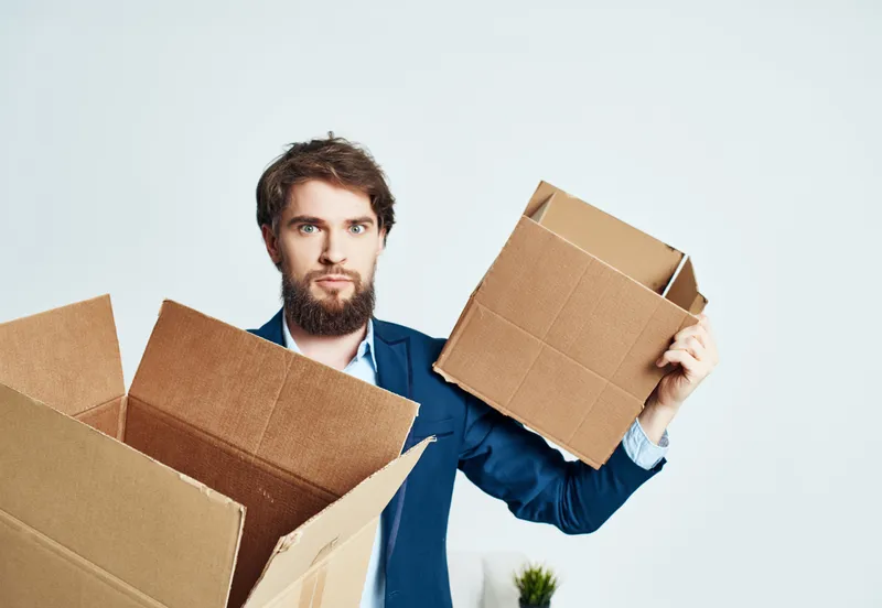 Менеджер с коробками вещей переезжает в офис