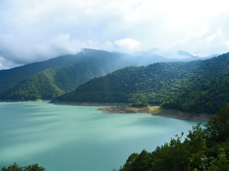 Пейзаж озера, гор, воды и леса с облаками, водохранилищем, холмами и зеленью, запечатленный с высокой точки обзора