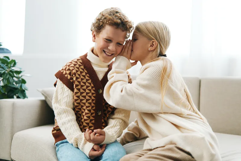 Authenticity shines as children share a playful moment in a cozy living room, a school themed lifestyle scene showing genuine smiles and candid interaction.