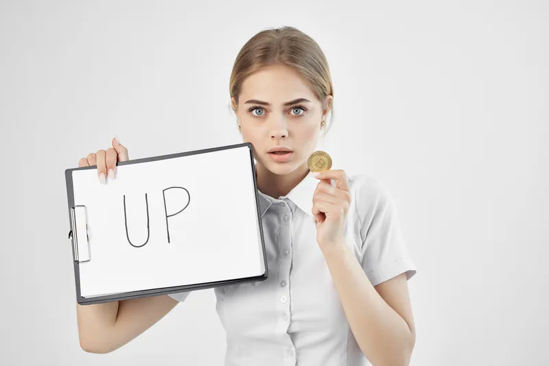 Деловая женщина держит вверх лист бумаги с надписью Bitcoin