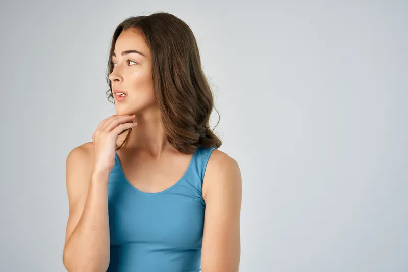 Жизнерадостная брюнетка с модной прической в синей майке-борцовке ведет активный образ жизни