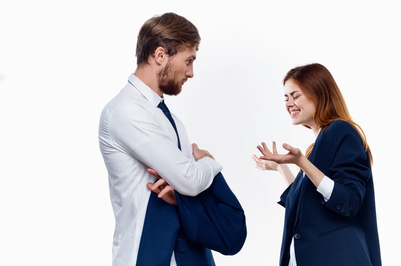 Мужчина и женщина, коллеги по работе, общаются в офисе на тему финансов