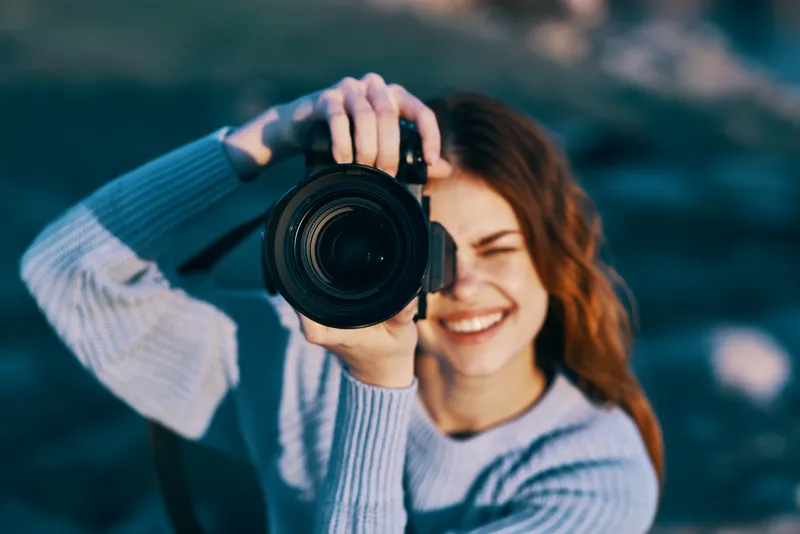 Симпатичная женщина-фотограф на фоне скалистых гор, крупный план, профессиональный снимок