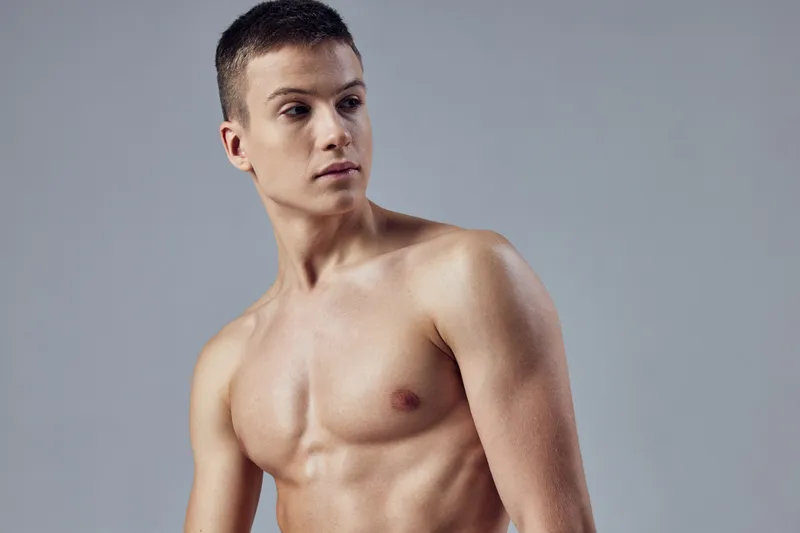 Мужчина с обнаженным телом, накачанный торс, привлекательный взгляд, изолированный фон