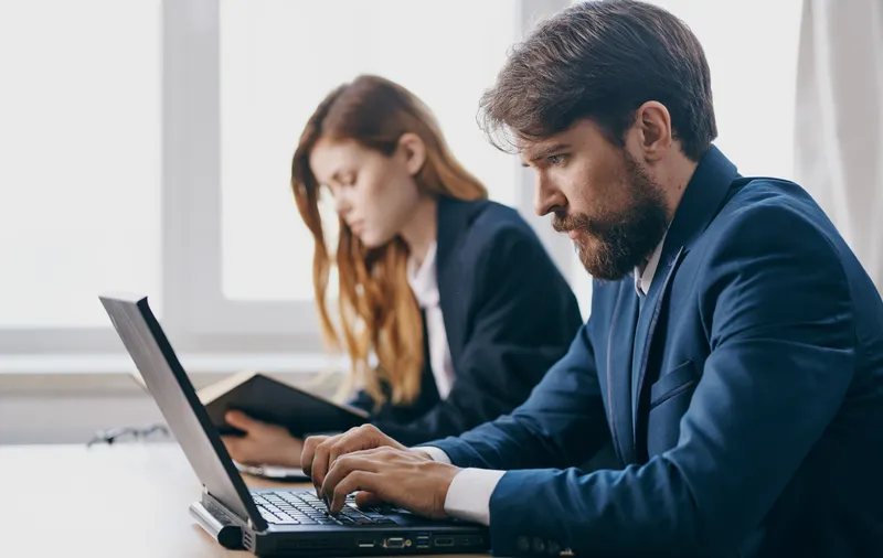 Коллеги по работе за офисным столом, технологии, финансовые профессионалы