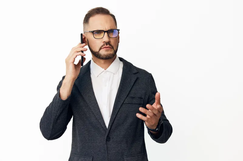 A professional man on a business call, showing confidence and focus while engaging in conversation. Isolated colorful background emphasizes a corporate mood and emotion.