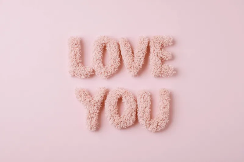 Игривые пастельно-розовые буквы, образующие фразу "Love You", идеально подходят для тем любви, романтических посланий, украшений ко Дню святого Валентина или поздравительных открыток