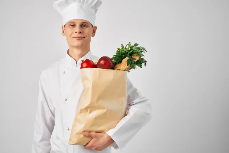 Мужчина доставляет продукты в рестораны в рамках сервиса доставки