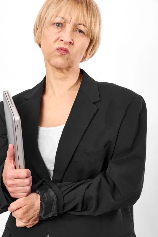 Woman, businesswoman, elderly, serious, studio portrait, holding folder, black suit, crossed arms, neutral expression, clean white background, corporate concept