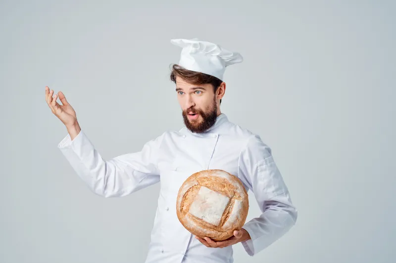 Бородатый мужчина-повар на кухне, работа, хлебобулочные изделия, светлый фон