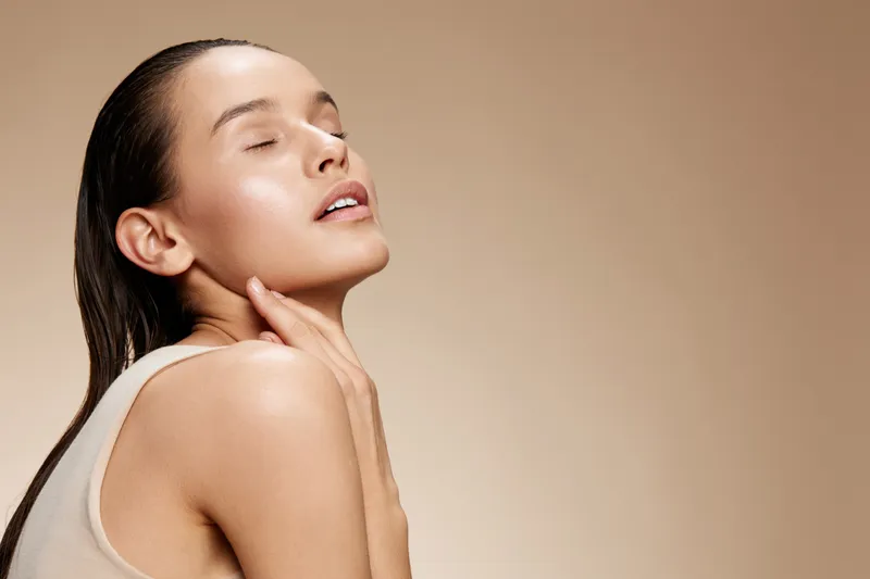 Beautiful young woman with glowing skin, closed eyes, and serene expression in neutral background, perfect for wellness, beauty, and skincare concepts