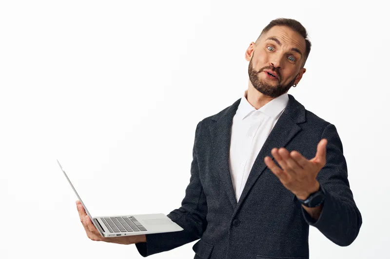 Professional businessman on an isolated colored background, holding a laptop and speaking with confidence, showcasing enthusiasm, approachability, and strong leadership for corporate appeal.