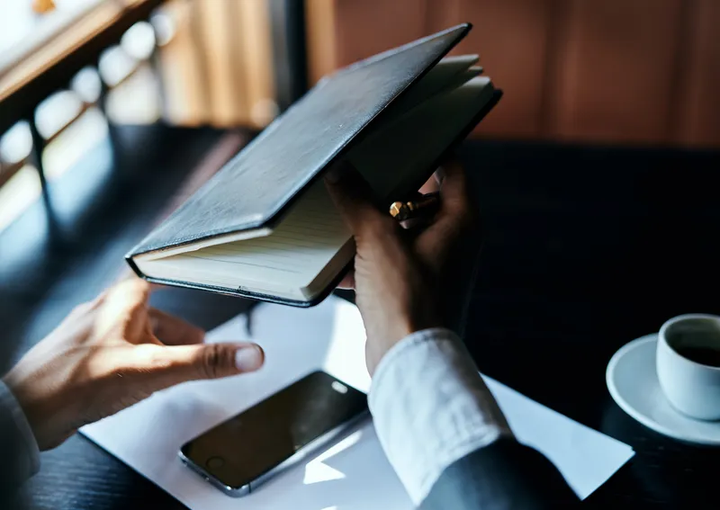 Бизнесвумен в кафе с книгой на столе, документами, чашкой кофе, работа, образ жизни