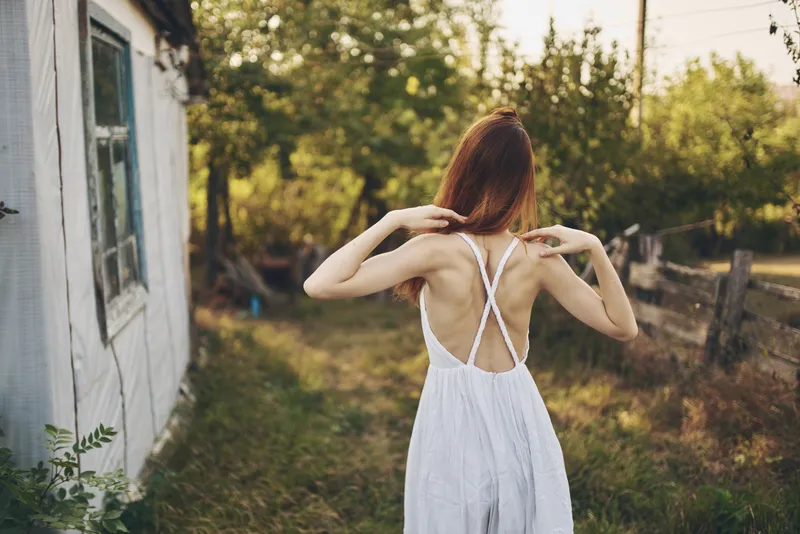 Красивая женщина гуляет по полю в деревне