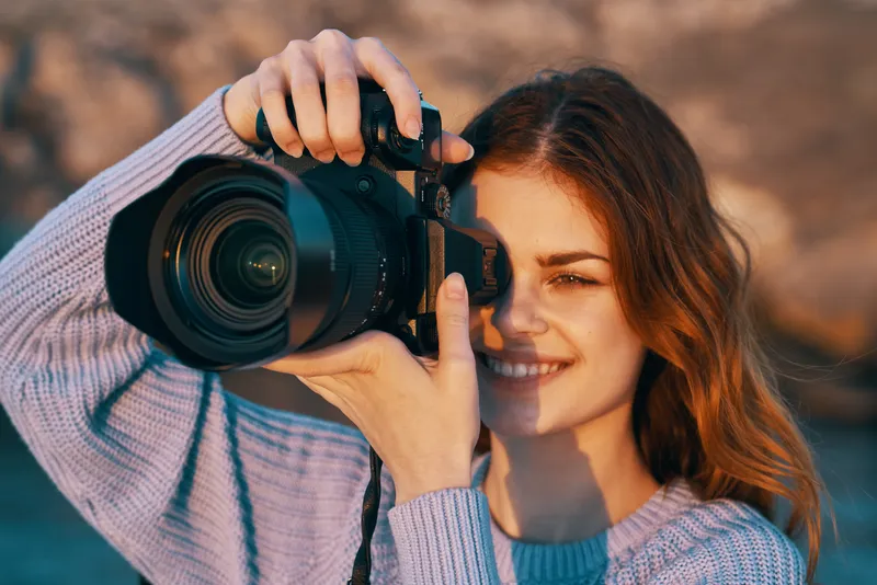 Счастливая женщина-фотограф на открытом воздухе в горах, профессиональная модель на фоне пейзажа