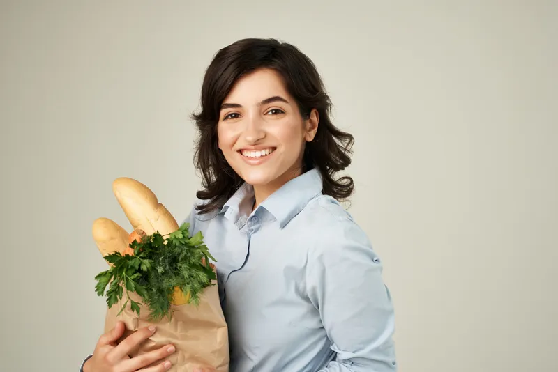 Женщина с пакетом продуктов в супермаркете