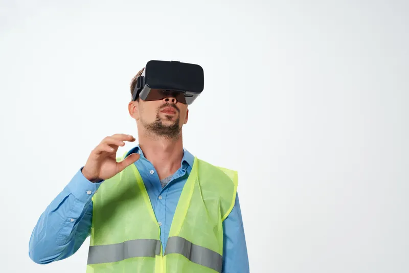 Инженер в белой каске и VR-очках на изолированном фоне