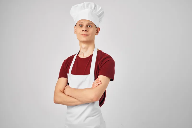 Шеф-повар мужского пола в белом фартуке, эмоция на кухне, профессионализм