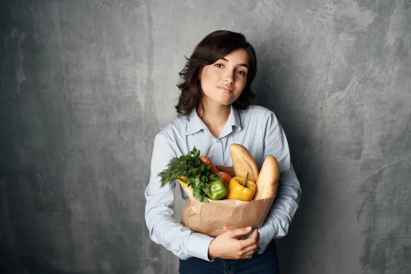Женщина с пакетом продуктов: здоровая еда, овощи, покупки в супермаркете