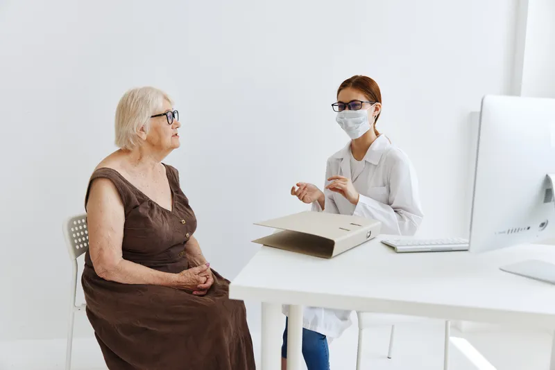 Врачи в медицинском кабинете проводят осмотр пациента, оказывая медицинскую помощь