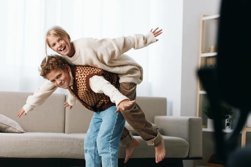 Authenticity shines in a playful home scene with a couple and child, capturing real laughter, casual style, and a warm family lifestyle during spontaneous play.