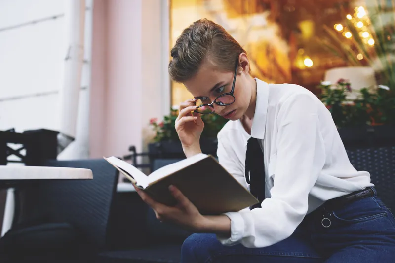Коротко стриженная женщина с книгой в руках, читает, образ жизни