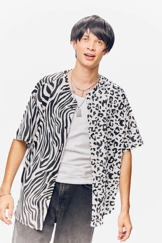 young man wearing black and white animal print shirt posing against white background with casual style and modern haircut in studio lighting