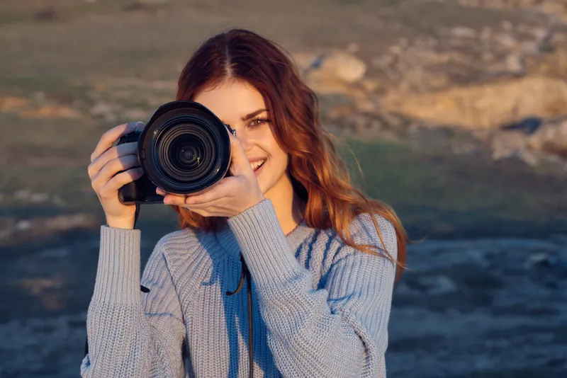 Женщина-турист с фотоаппаратом наслаждается пейзажем и природой во время отпуска и путешествия