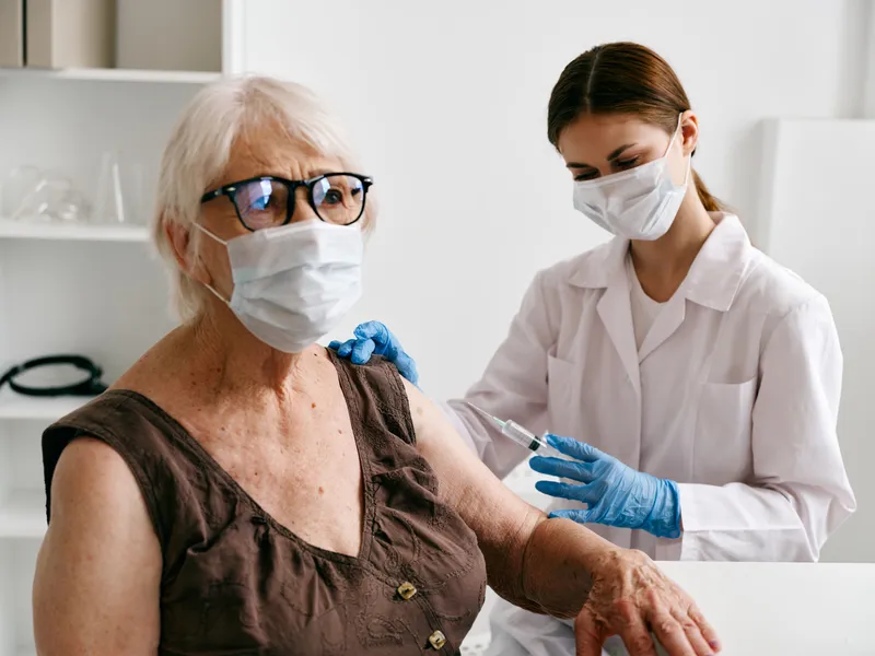 Медсестра делает инъекцию пожилой женщине, вакцинный паспорт, covid-19, здоровье