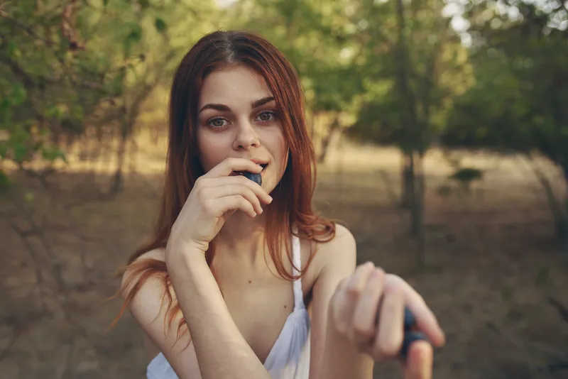 Крупный план симпатичной женщины, которая ест виноград