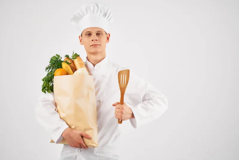 Шеф-повар с упаковкой свежих продуктов на кухне, профессиональная работа