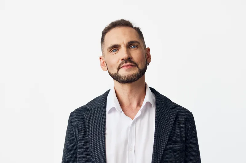 A professional business man stands against a clean, isolated background, projecting confidence, focus, and calm determination in a modern corporate setting with a refined, sharp appearance.