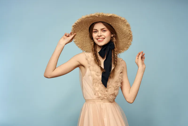 Девушка в розовом платье на синем фоне жестикулирует руками