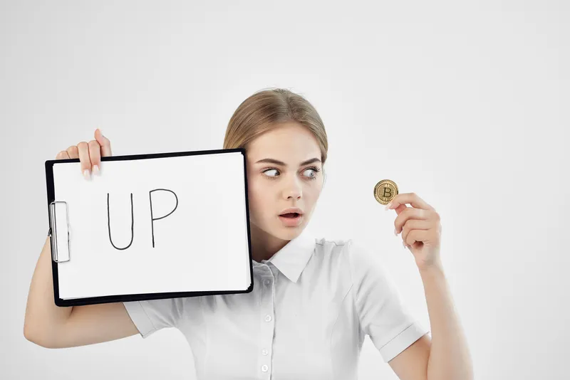 Женщина держит папку с надписью «Up Cryptocurrency Finance»