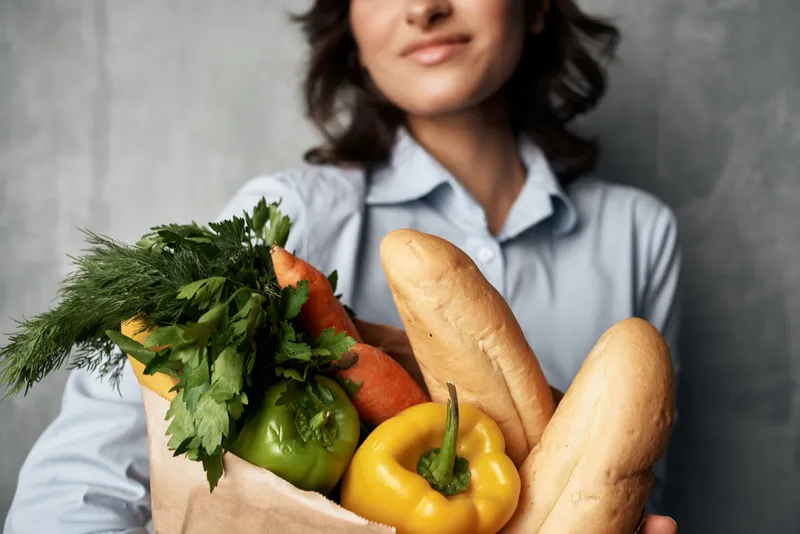 Женщина держит пакет с продуктами