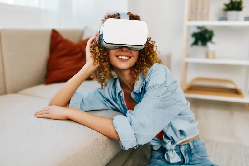 Счастливая женщина наслаждается футуристической VR-игрой дома