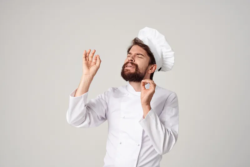 Бородатый мужчина-шеф-повар занимается кулинарией в кулинарной индустрии на светлом фоне