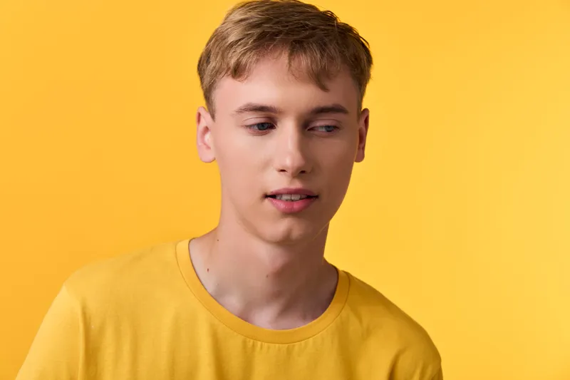 Yellow themed image of a young man in a casual t shirt against a bright background, conveying contemporary style, color balance and fashion mood for lifestyle and product presentation