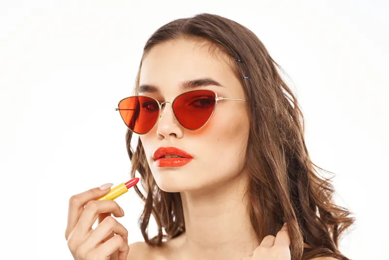 Модная брюнетка в солнцезащитных очках с макияжем и помадой