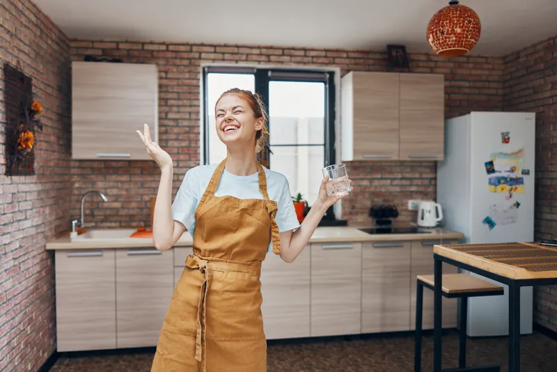 Женщина в коричневом фартуке на кухне